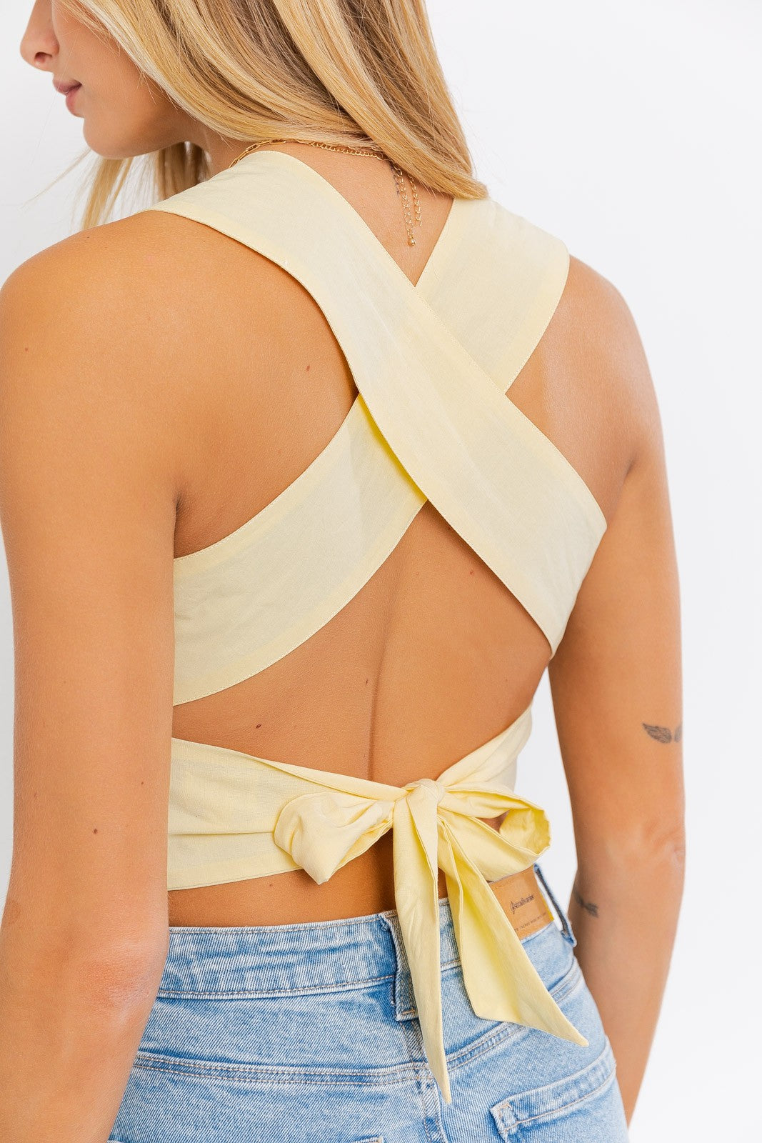 Introducing the Emma Smocked Peplum Top with a criss-cross back tie, a charming and fashionable addition to your wardrobe. This top features a sleeveless design that's perfect for warm days and a flattering peplum silhouette that adds a touch of flair. The smocked detailing enhances your figure and creates a comfortable fit, while the criss-cross back tie adds a playful and stylish accent, allowing for a customized fit.