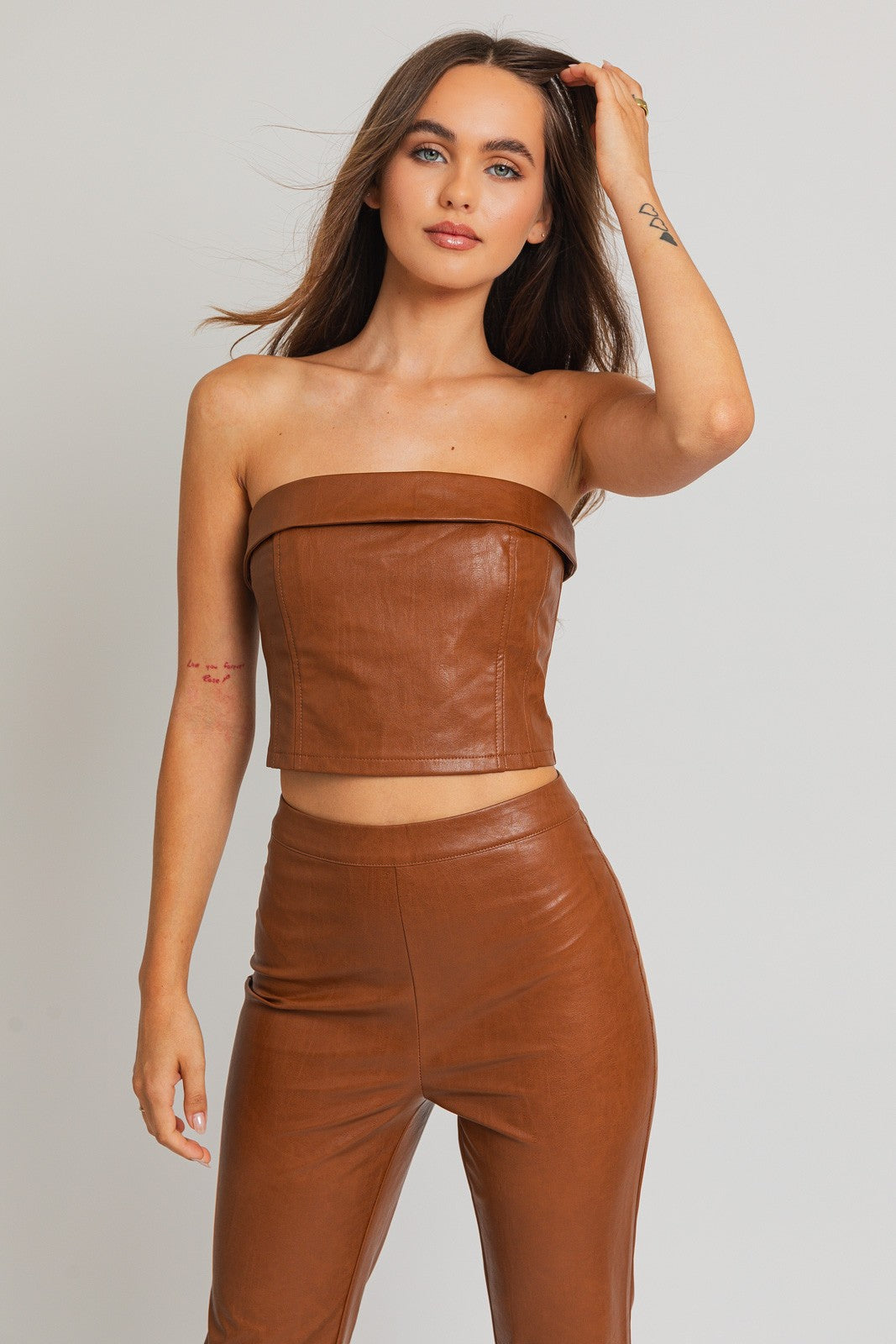 Revamp your wardrobe with our Emelie Faux Leather Corset Tube Top, a daring and chic addition to your collection. This trendy piece seamlessly combines the classic allure of a tube top with the edgy sophistication of a corset. The structured design enhances your silhouette, providing a flattering and on-trend look.