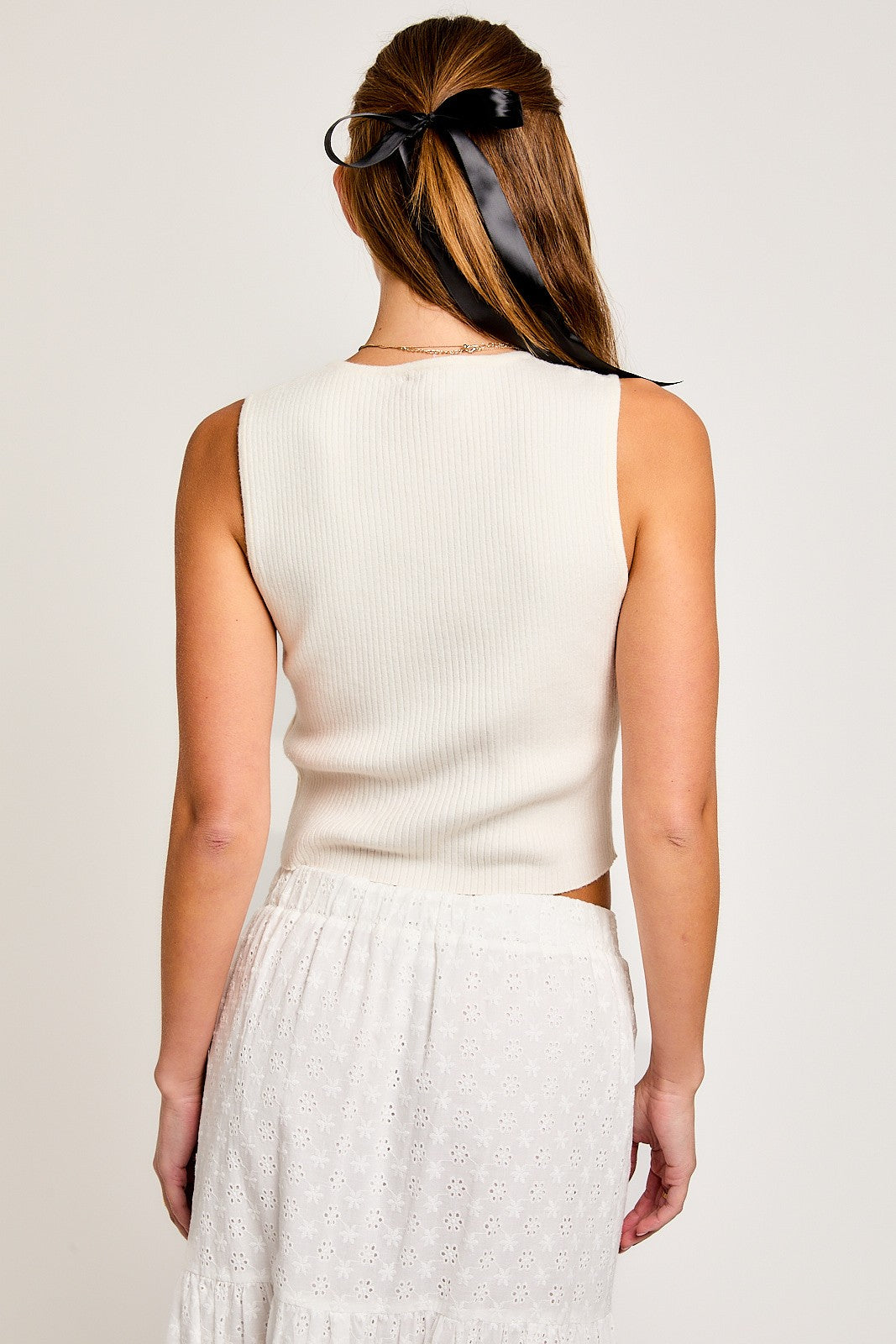 Add elegance to your style with this chic Satin Bow Sleeveless Sweater Top. Made from a soft, lightweight knit, this top has a classic sleeveless design and a feminine satin bow on the front. Perfect for any occasion, pair it with skirts, trousers, or jeans for a stylish and versatile look.
