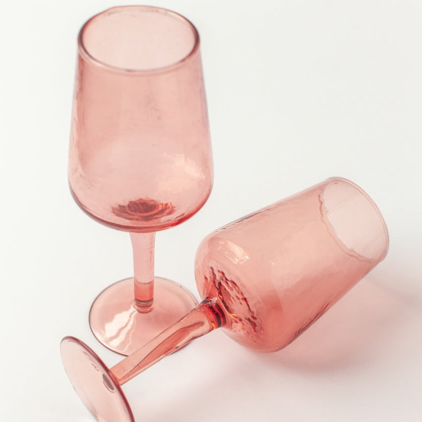 Each of these wine glasses tells a story of craftsmanship refined across generations. Handblown then meticulously hammered by hand, each generously sized glass features a beautiful, pebbled texture and subtle color.
Ethically made by a woman-owned company, this recycled glass collection aims to support people and the planet. We use colored glass (not sprayed) to ensure the color will last a lifetime. Please note that these items are 100% handmade and slight size variations and imperfections may occur.