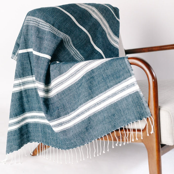 Lightweight and super-soft, this is easily the most versatile home textile ever. Its size works perfectly as a cozy wrap or decorative throw and our signature Aden striped design compliments any decor. And did we mention it's also the perfect travel accessory? Hand-spun Ethiopian cotton adds a uniquely rich texture that will continue to soften and become more absorbent with each wash/dry.
Measures 38 x 72 inches. Ethically crafted in Ethiopia.