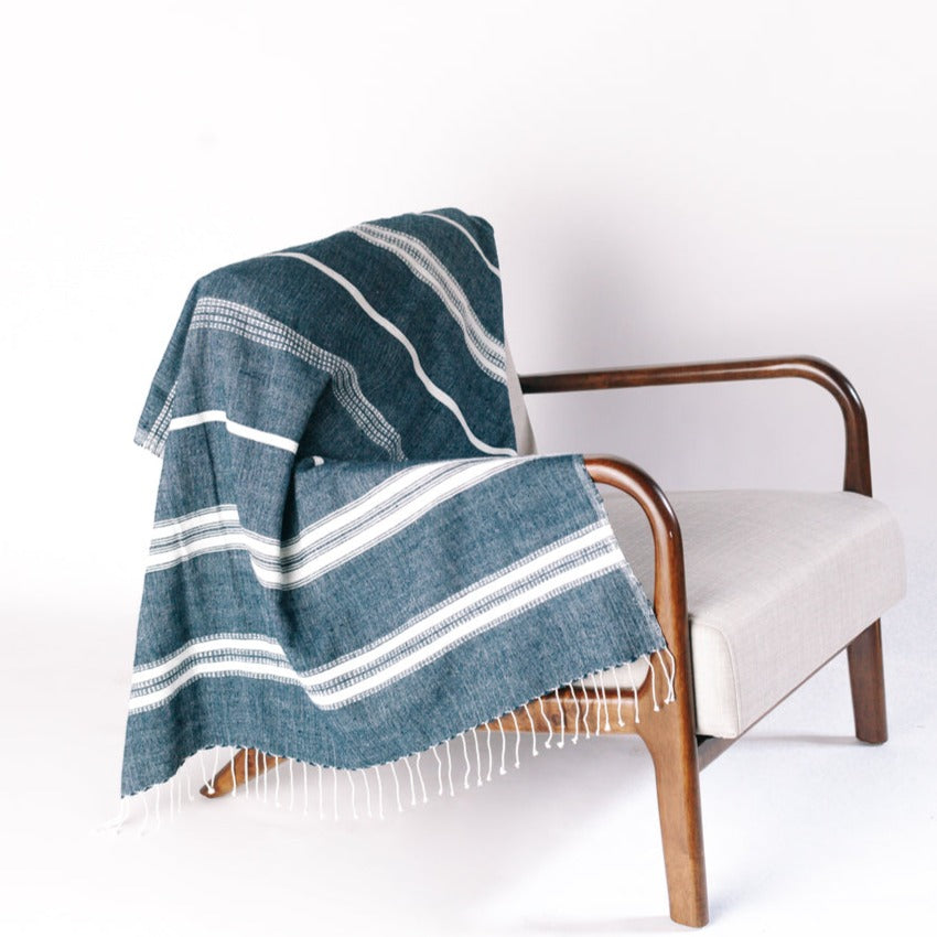 Lightweight and super-soft, this is easily the most versatile home textile ever. Its size works perfectly as a cozy wrap or decorative throw and our signature Aden striped design compliments any decor. And did we mention it's also the perfect travel accessory? Hand-spun Ethiopian cotton adds a uniquely rich texture that will continue to soften and become more absorbent with each wash/dry.
Measures 38 x 72 inches. Ethically crafted in Ethiopia.