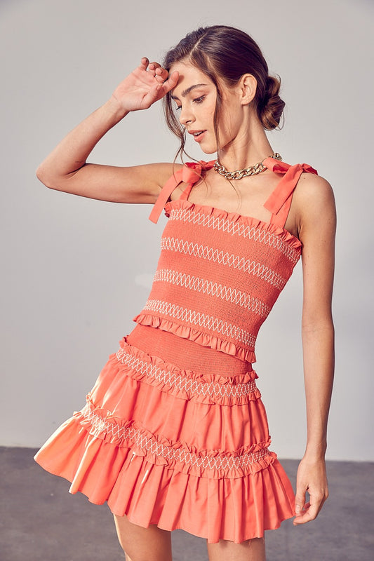 Add some serious charm and style into your wardrobe with the Coral  Smocked Bow Strap Top. Whether you rock it casually with jeans or match it up with the Coral Tiered Ruffle Skirt for a flirty edge, this top has got you covered.  Model is 5'9" and is wearing a size Small Bust: 32", Waist: 24", Hips: 34"