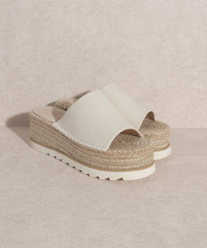 Walk with grace and style in the Ivy Espadrille Platform Slide. The perfect casual and comfortability footwear. With its unique platform design and handcrafted construction, the Ivy Espadrille Platform Slide provides unmatched support and a luxurious feel with each step. Say goodbye to sacrificing comfort for style and experience true luxury with these slides.