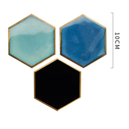 Unleash your inner creativity and add a touch of sophistication with this set of four hexagonal coasters, accented with gold edges and suede lining. Use them individually or combine them to create a heat-resistant base for hot dishes. Available in black, blue, and aqua, the possibilities are endless.  Ceramic Diameter: 4" Thermal insulation Set includes 4 pieces