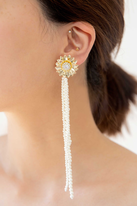 Experience refined elegance with our Cute Dandelion Studs featuring delicate pearls strands that dance gracefully. Crafted with sterling silver posts and enhanced with 14k gold plating, these studs add a touch of sophistication to any ensemble. Embrace the whimsical charm of dandelions and let the dangling pearls make a statement of refined style. Perfect for everyday wear or a special occasion, these earrings effortlessly blend modern chic with timeless allure.