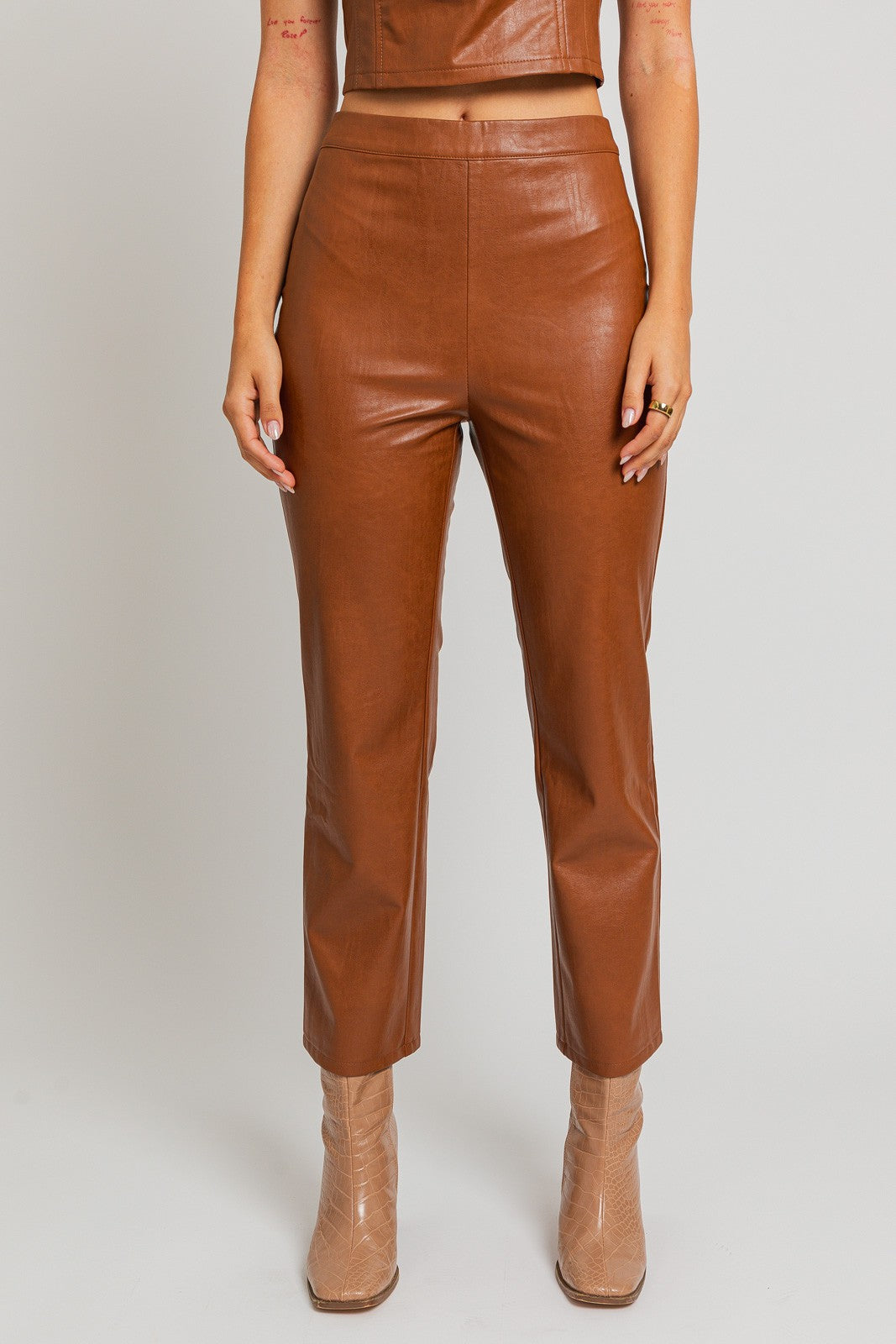 Introducing our Emelie Faux Leather Straight Pants - a versatile wardrobe staple that seamlessly combines comfort with edgy style. These pants boast a classic straight-leg silhouette, providing a flattering and polished look for any occasion.