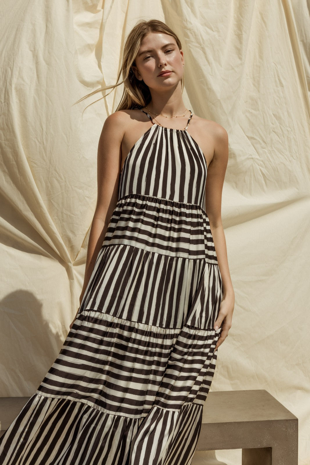 Get ready for effortless style with our Sleeveless Stripe Maxi Tiered Dress! This dress exudes laid-back elegance with its sleeveless design and tiered silhouette, offering a relaxed yet flattering fit for any body type.