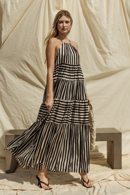 Get ready for effortless style with our Sleeveless Stripe Maxi Tiered Dress! This dress exudes laid-back elegance with its sleeveless design and tiered silhouette, offering a relaxed yet flattering fit for any body type.