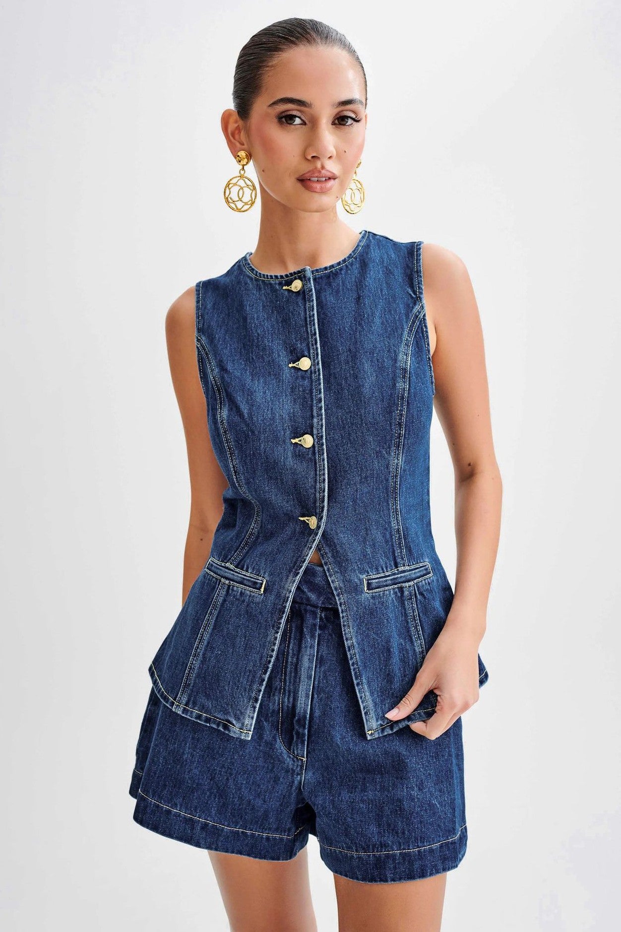 The Gianna Denim Two Piece Set combines stylish denim vest and shorts, designed with a round neck and sleeveless cut for a chic finish that will elevate your summer wardrobe.