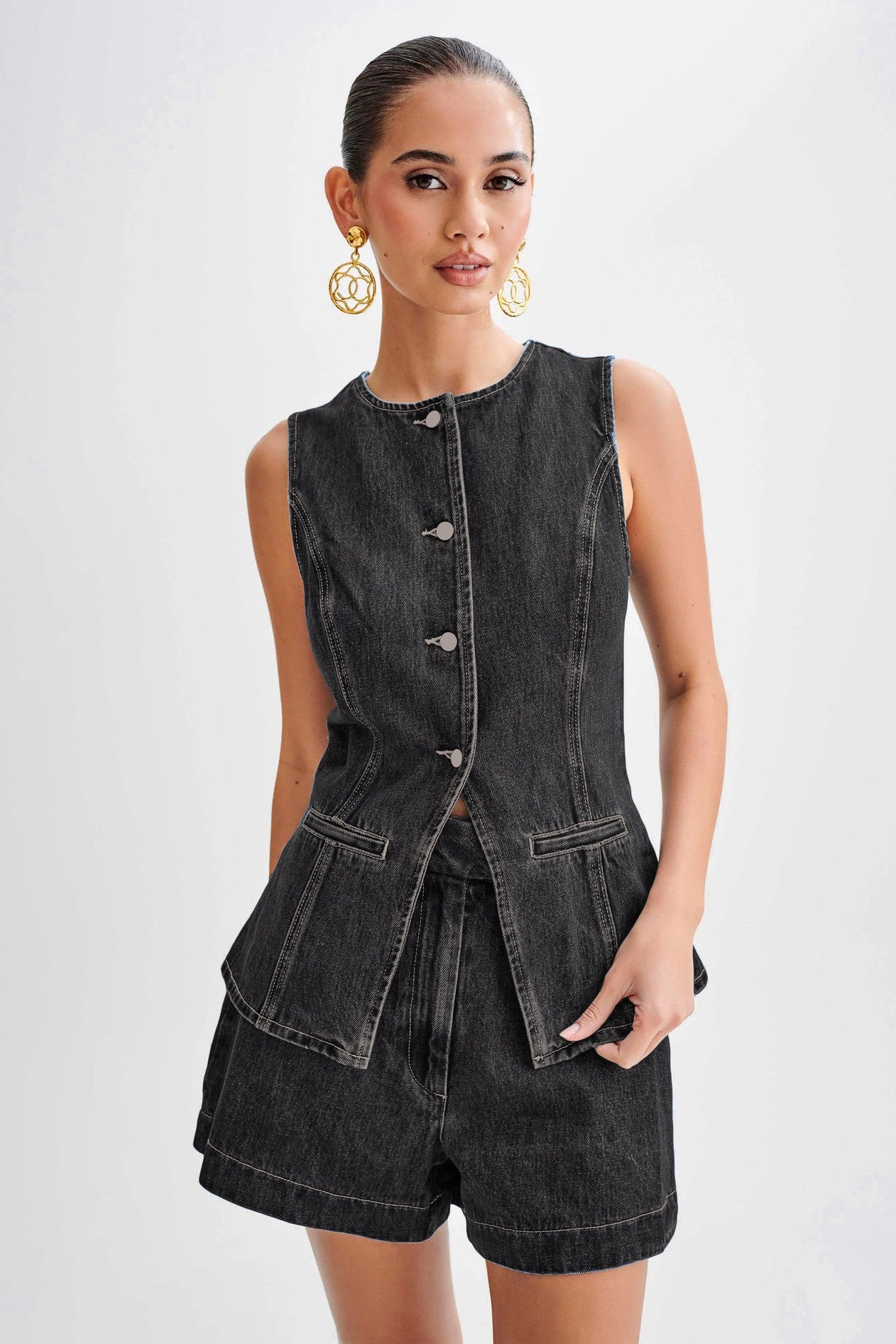 The Gianna Denim Two Piece Set combines stylish denim vest and shorts, designed with a round neck and sleeveless cut for a chic finish that will elevate your summer wardrobe.