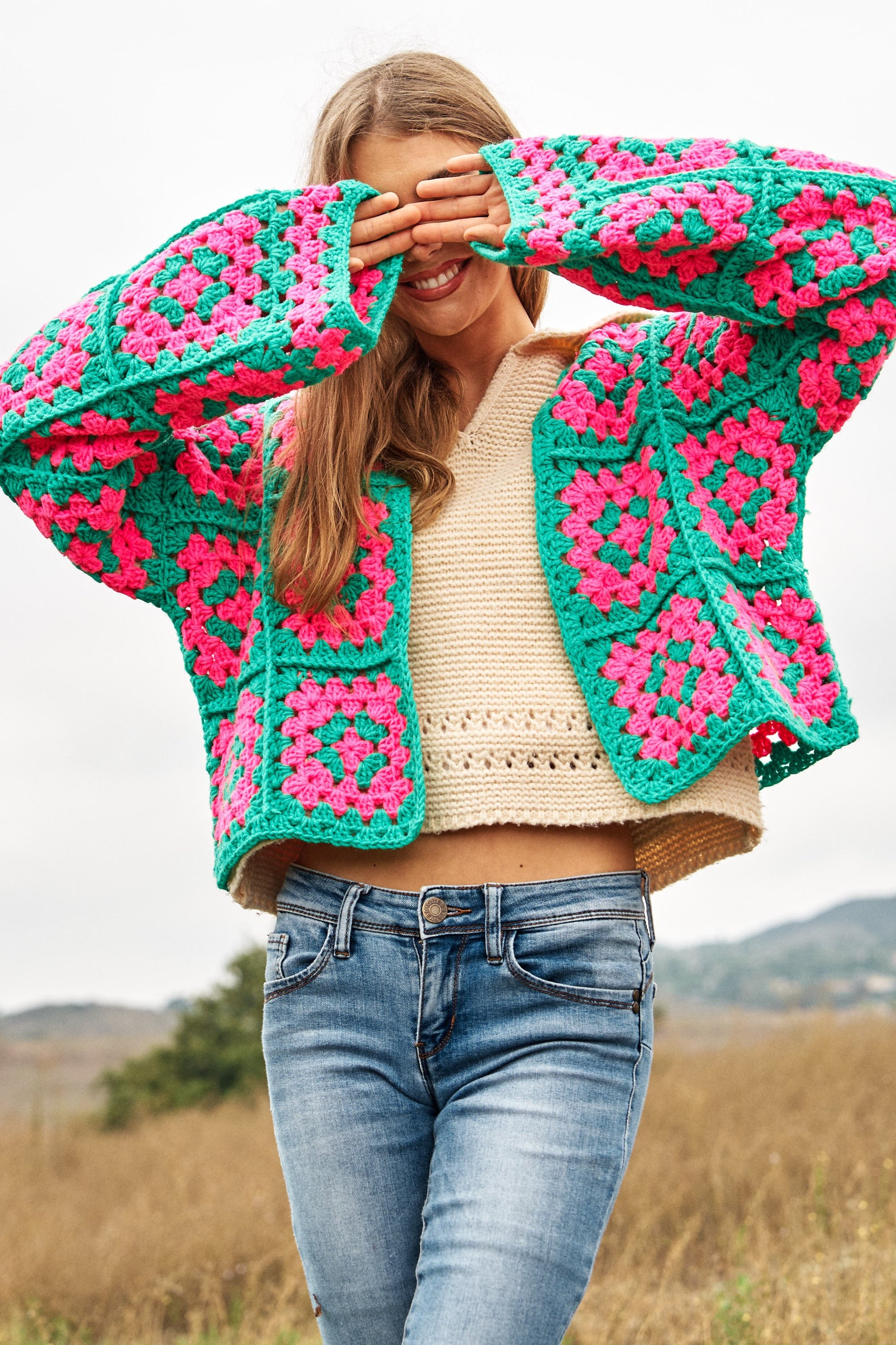 Introducing our Two-Tone Floral Square Crochet Open Knit Cardigan-a bohemian-inspired masterpiece that seamlessly blends style and craftsmanship. This cardigan showcases a captivating two-tone color palette and features a square crochet open knit design adorned with intricate floral patterns.