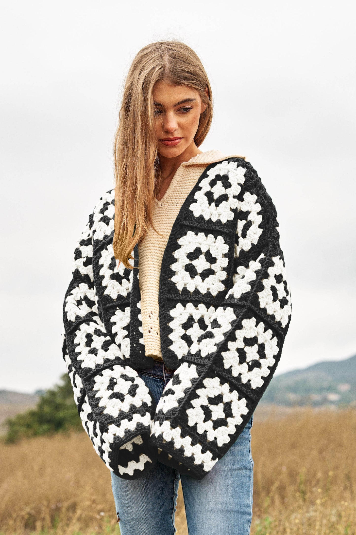 Introducing our Two-Tone Floral Square Crochet Open Knit Cardigan-a bohemian-inspired masterpiece that seamlessly blends style and craftsmanship. This cardigan showcases a captivating two-tone color palette and features a square crochet open knit design adorned with intricate floral patterns.