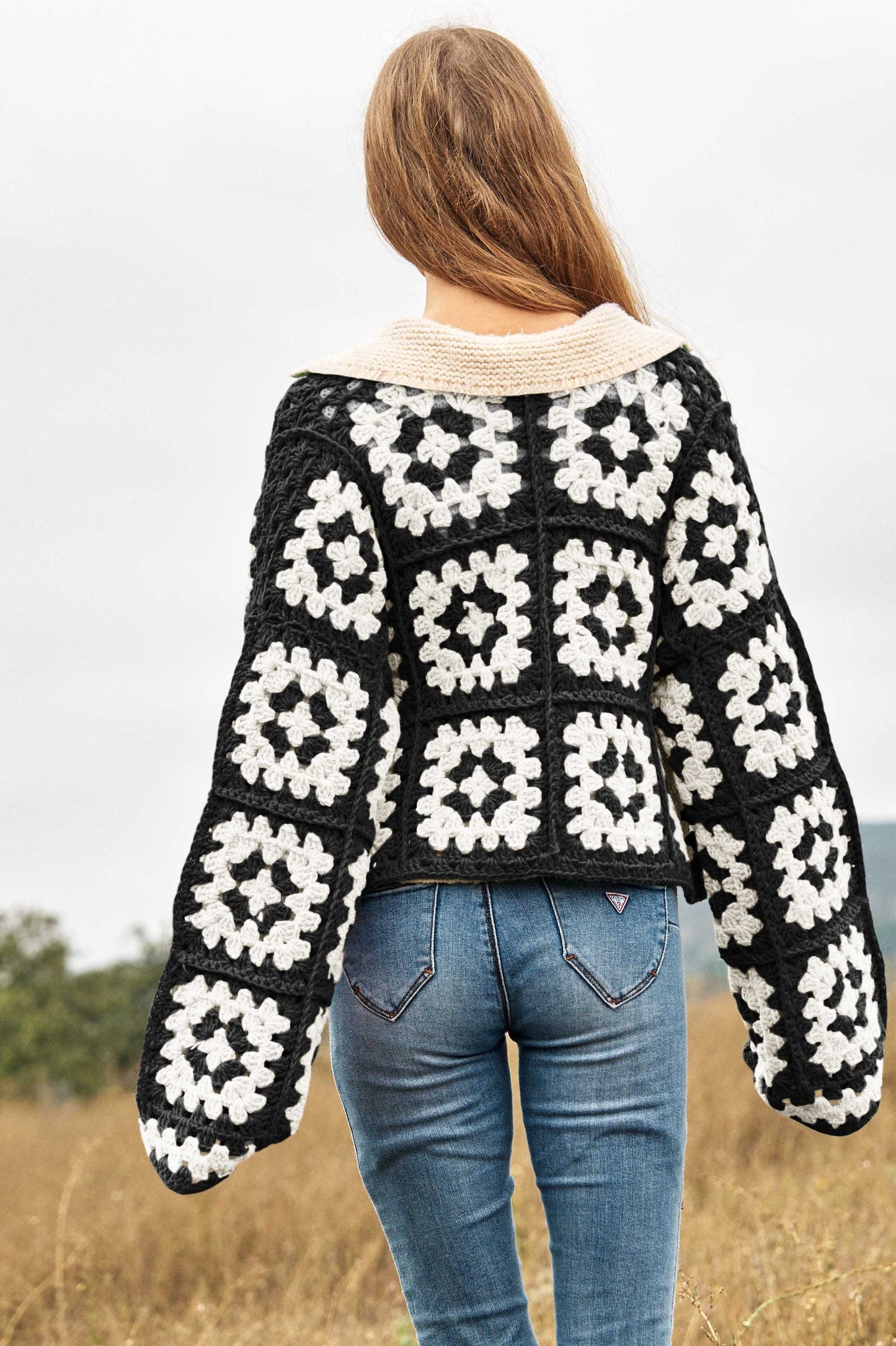 Introducing our Two-Tone Floral Square Crochet Open Knit Cardigan-a bohemian-inspired masterpiece that seamlessly blends style and craftsmanship. This cardigan showcases a captivating two-tone color palette and features a square crochet open knit design adorned with intricate floral patterns.