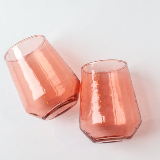 Sip in style with these hand-blown hammered glass tumblers. Crafted with care at a woman-owned business, each is made from 100% recycled glass and meticulously hammered by hand for a truly unique finish. Master craftsmanship, beautiful texture and organic lines makes these perfect for everyday use or at your next dinner party. This collection is made from colored glass (not sprayed) to ensure the color will last a lifetime.