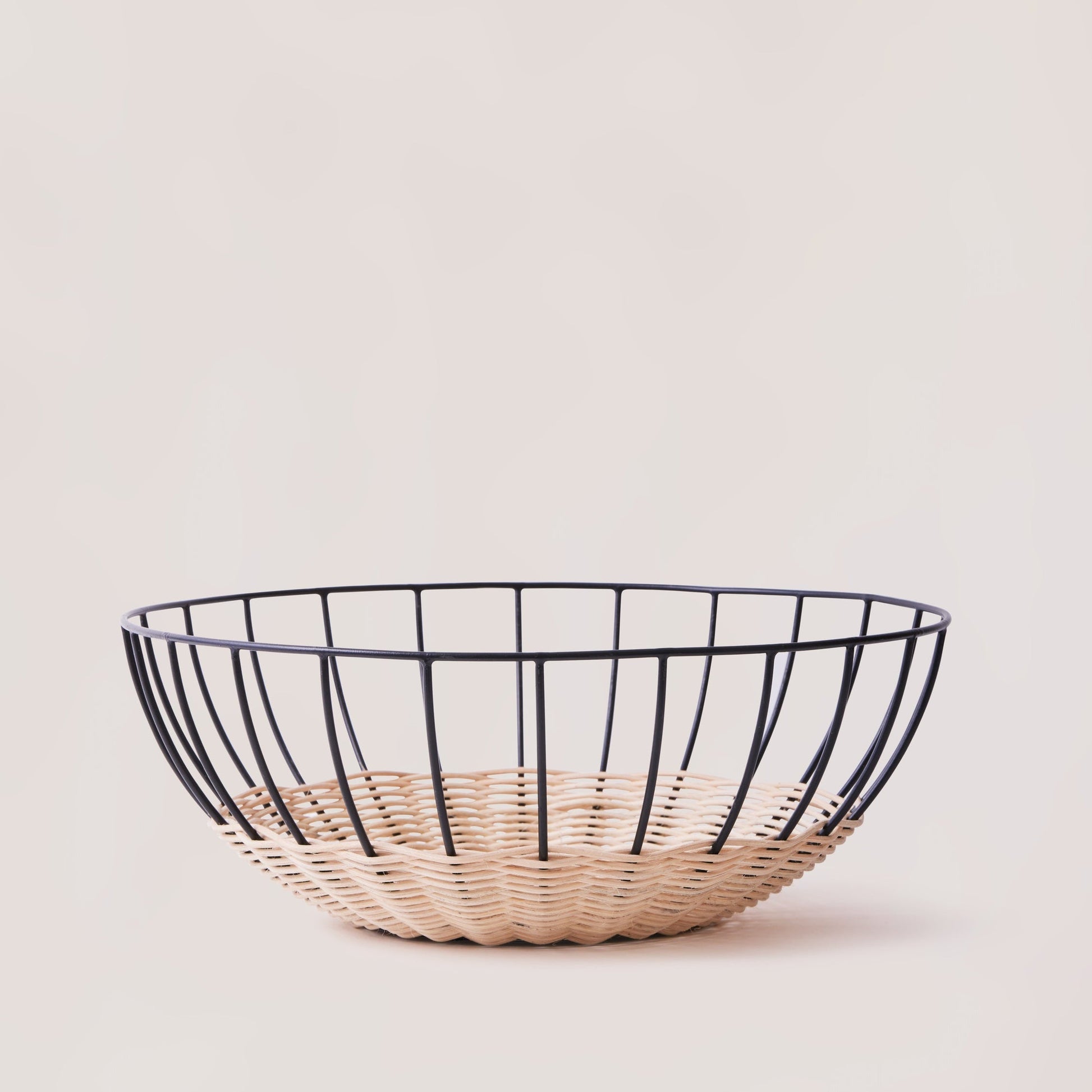 The Cabo Rattan Basket turns your grocery store produce into a beautiful still-life piece. Woven with natural rattan, this airy basket would elevate your centrepiece display of fruit, vegetables or ornamental objects. 
    * Natural Rattan on Powder coated Iron
    * Size:  35 cms Width x 12 cms Height / 13.8" round x 4.72" Height
Note: Please keep away from high moisture places. Wipe clean with a dry soft cloth. 