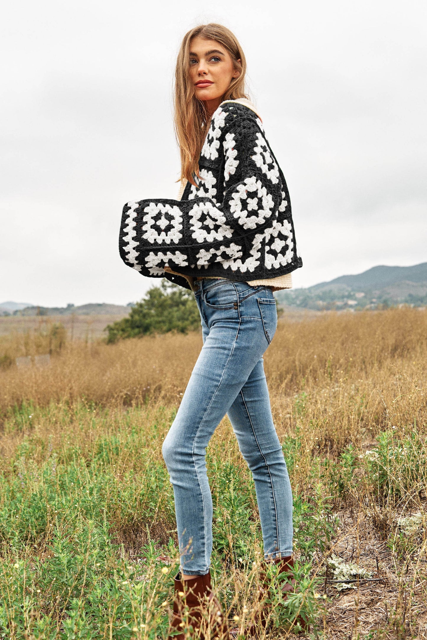 Introducing our Two-Tone Floral Square Crochet Open Knit Cardigan-a bohemian-inspired masterpiece that seamlessly blends style and craftsmanship. This cardigan showcases a captivating two-tone color palette and features a square crochet open knit design adorned with intricate floral patterns.