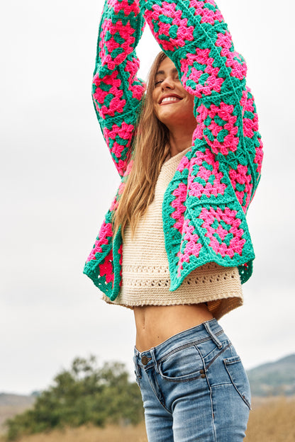 Introducing our Two-Tone Floral Square Crochet Open Knit Cardigan-a bohemian-inspired masterpiece that seamlessly blends style and craftsmanship. This cardigan showcases a captivating two-tone color palette and features a square crochet open knit design adorned with intricate floral patterns.