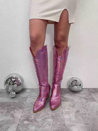 Introducing our knee-high metallic cowboy boots—a fusion of timeless Western charm and futuristic allure. Crafted with attention-grabbing metallic finishes, these boots make a bold statement that effortlessly enhances any ensemble. The sturdy block heel combines style with comfort, while intricate detailing pays homage to the classic cowboy boot design. Step into a distinctive blend of tradition and modernity with these eye-catching boots.